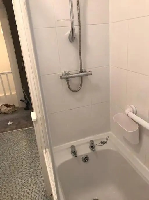 a bathroom with a bath tub with a shower at Heather House, beautiful family home, sleeps 8 in Inverness