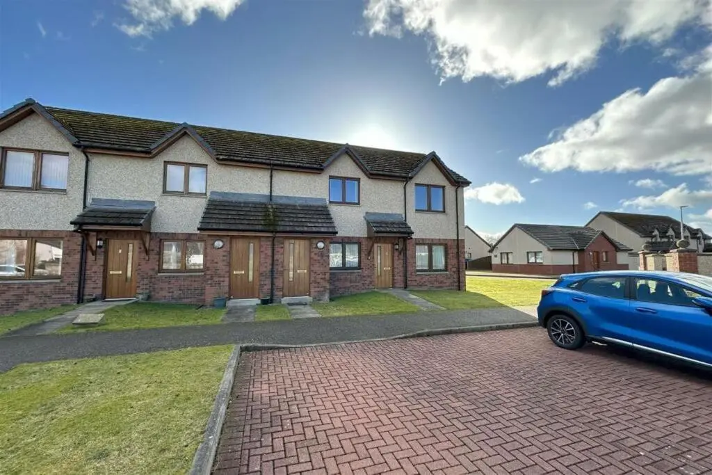 a blue car parked in front of a house at The Old Mill Apartment, on NC500 in Brora