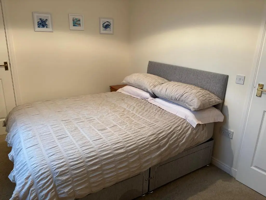a bedroom with a bed with a pillow on it at The Old Mill Apartment, on NC500 in Brora