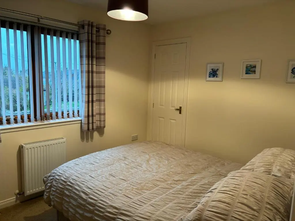 a bedroom with a bed and a window at The Old Mill Apartment, on NC500 in Brora