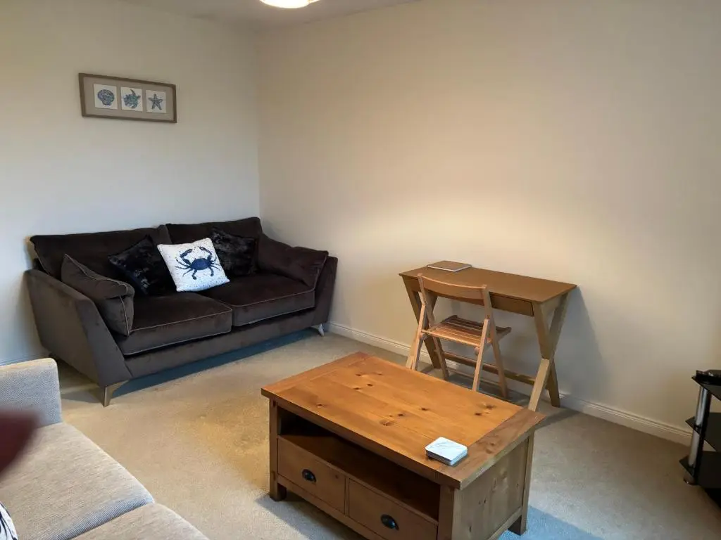 a living room with a couch and a coffee table at The Old Mill Apartment, on NC500 in Brora