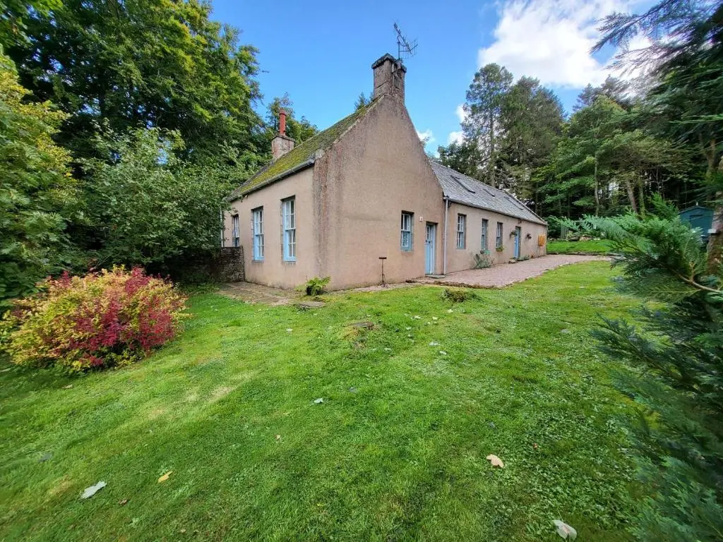 an old brick building in a grassy yard at Spacious Cottage in the Grounds of a Scottish Castle in Insch