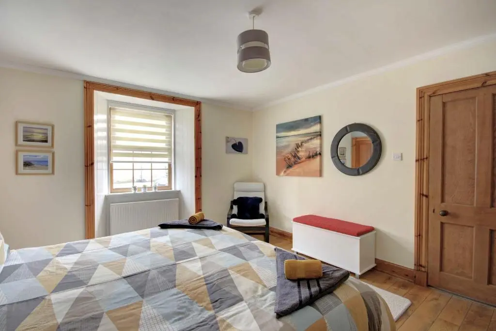 a bedroom with a bed and a window at The Apartment at Allt-Sagart in Golspie