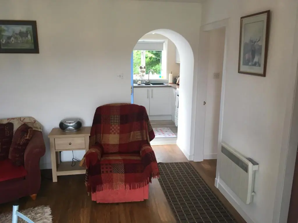 a living room with a couch and a chair at Ruthven House Holiday Cottages in Kingussie