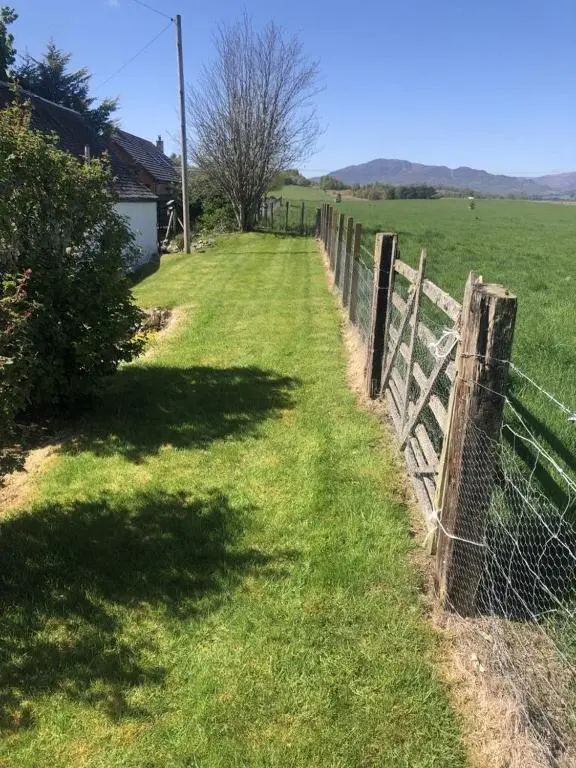 a fence in the middle of a field at Ruthven House Holiday Cottages in Kingussie