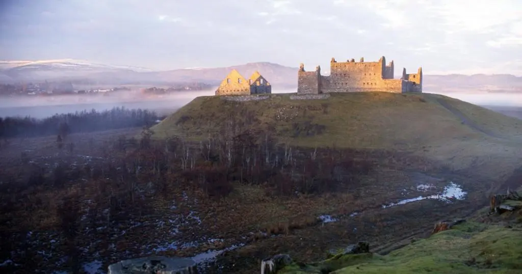 a castle on the top of a hill at Ruthven House Holiday Cottages in Kingussie
