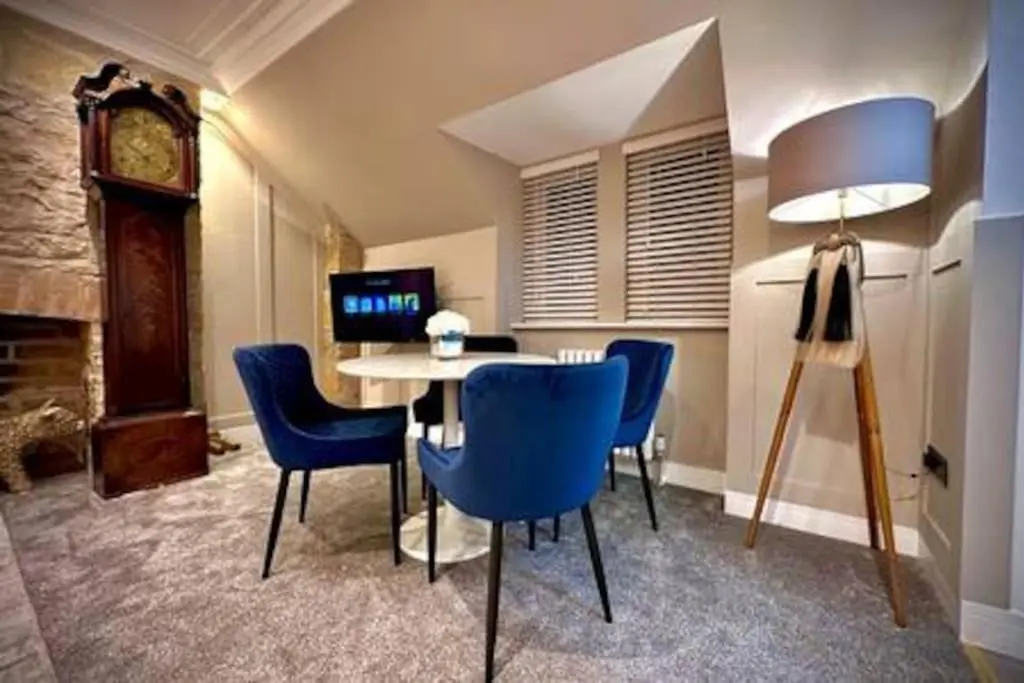a dining room with a table and chairs and a clock at Treat Yourself To Luxury & Style in Inverness