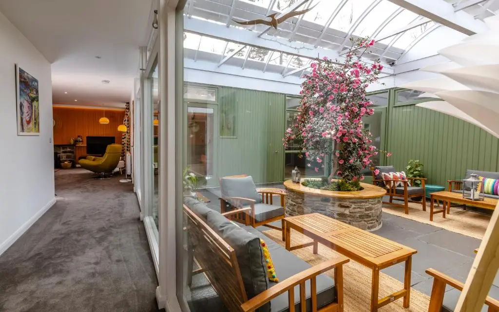 a room with a couch and tables and a plant at Strathy House in Aviemore