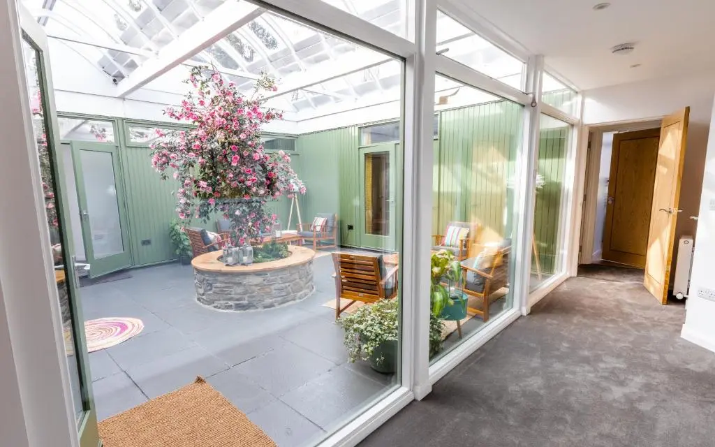a conservatory with a bunch of plants and flowers at Strathy House in Aviemore