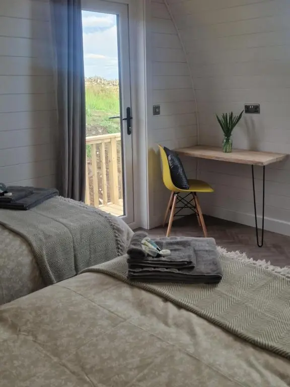 a bedroom with a bed and a desk and a chair at Bromach Lodge in Latheron