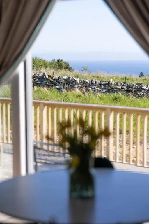 a table with a vase of flowers on a balcony at Bromach Lodge in Latheron