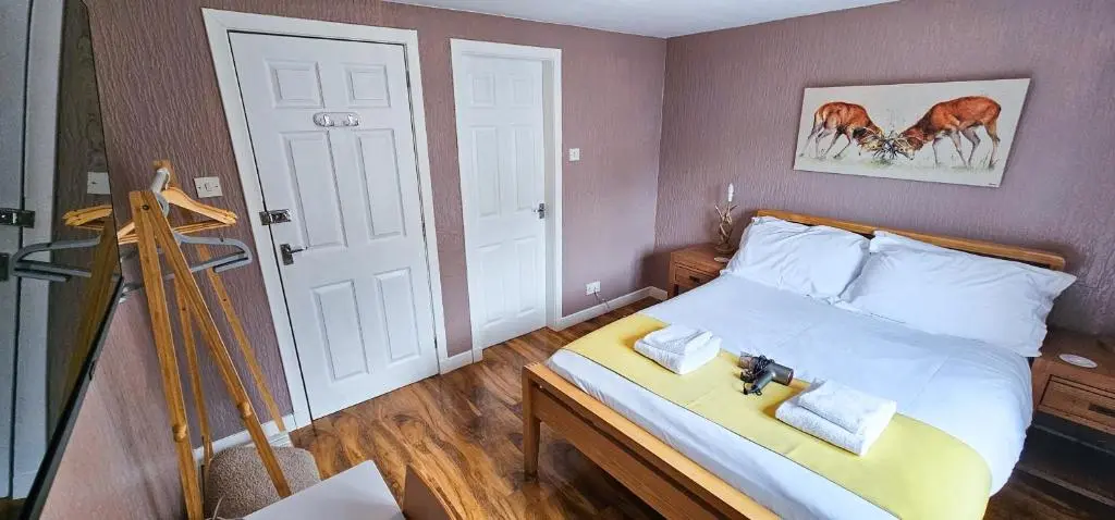 a small bedroom with a bed with a wooden frame at Cromarty 4 Bedroom Apartment - Inverness in Inverness