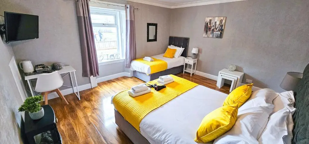 a hotel room with two beds and a television at Cromarty 4 Bedroom Apartment - Inverness in Inverness