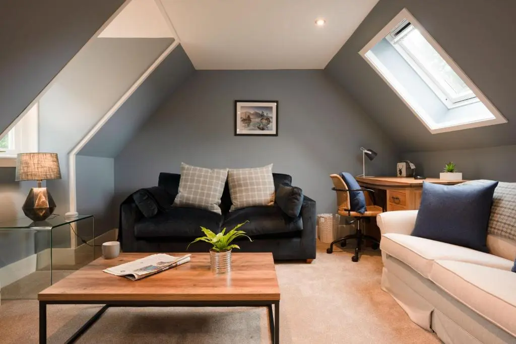 a living room with a couch and a table at The Dell of Rothiemurchus - Seasgair Lodges in Aviemore