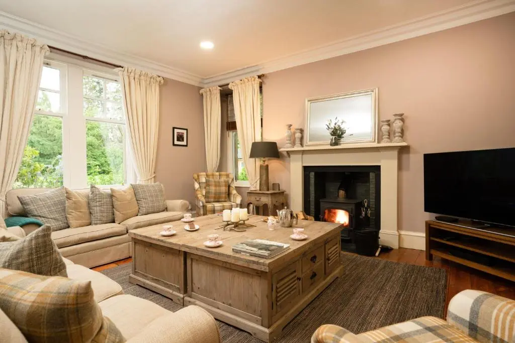 a living room with a couch and a coffee table at The Dell of Rothiemurchus - Seasgair Lodges in Aviemore