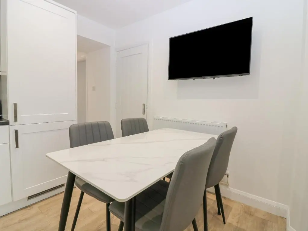 a white dining room with a white table and chairs at 2 College Bounds in Fraserburgh