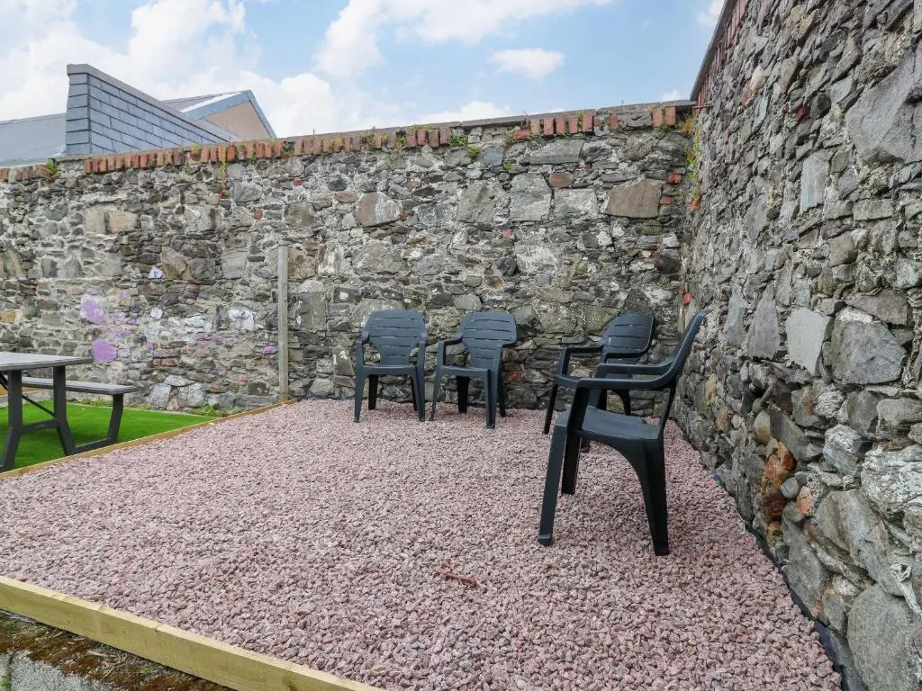 a group of chairs sitting in front of a stone wall at 2 College Bounds in Fraserburgh