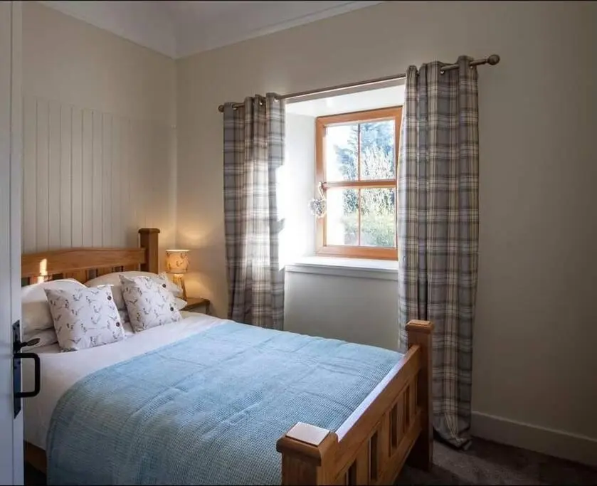a bedroom with a bed and a window at Torran Cottage - Views, Exclusivity & Tranquility in Halkirk