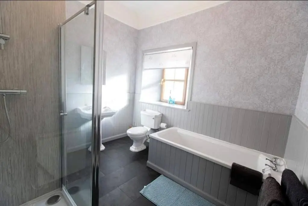 a bathroom with a tub and a toilet and a shower at Torran Cottage - Views, Exclusivity & Tranquility in Halkirk
