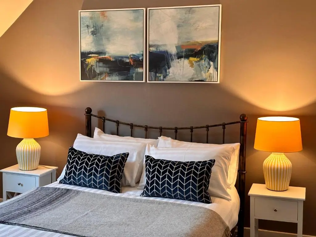 a bedroom with a bed with two lamps on it at Warm and Cosy City Centre House in Inverness