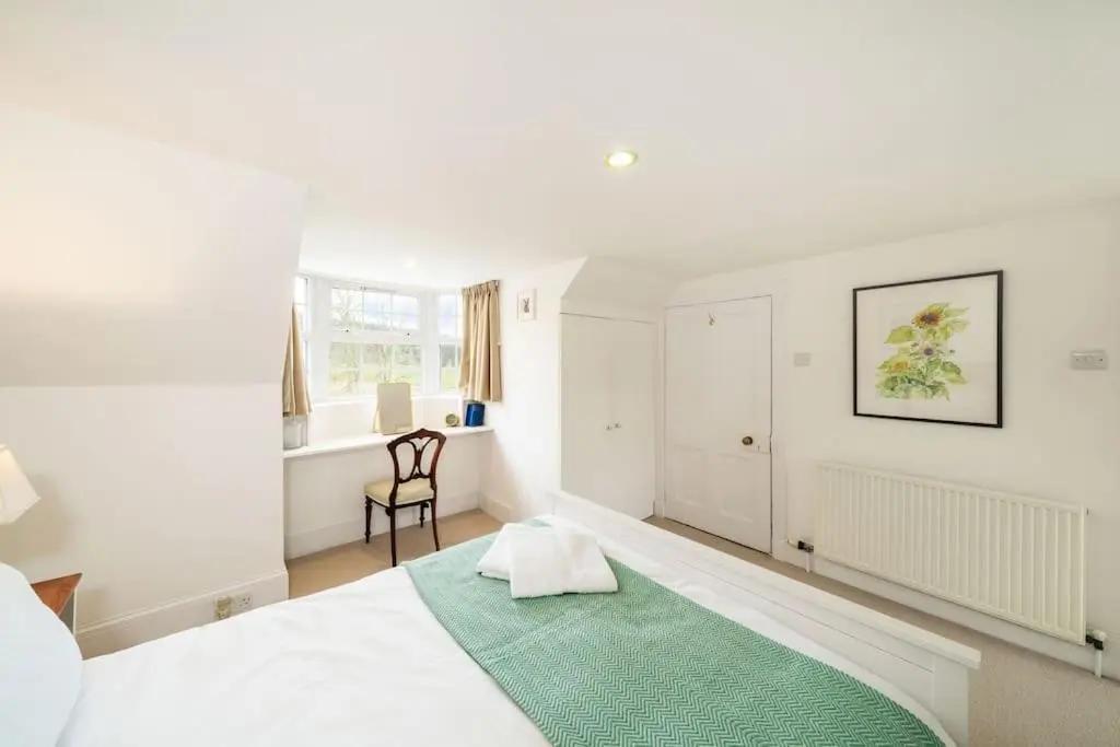 a white bedroom with a green rug on a bed at Westerpark Cottage, Pet & Family Friendly Countryside Retreat, Aberdeenshire in Huntly