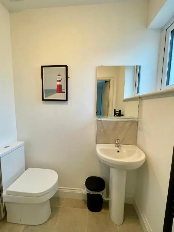 a bathroom with a white toilet and a sink at Modern Coastal Retreat, 5-Bedroom, 4-Bathroom Home, with Parking in Portsoy in Portsoy