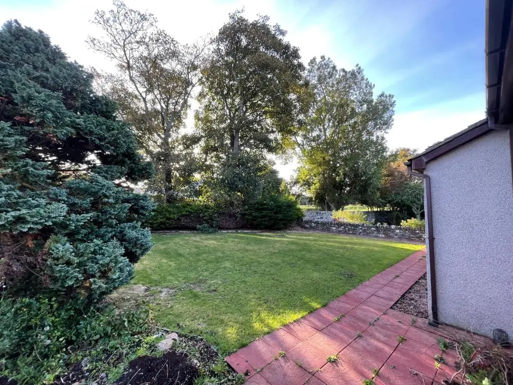 a backyard with a lawn and a brick walkway at Modern Coastal Retreat, 5-Bedroom, 4-Bathroom Home, with Parking in Portsoy in Portsoy