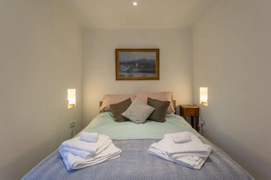 a bedroom with a bed with towels on it at The Bungalow - Ardullie Lodge in Dingwall
