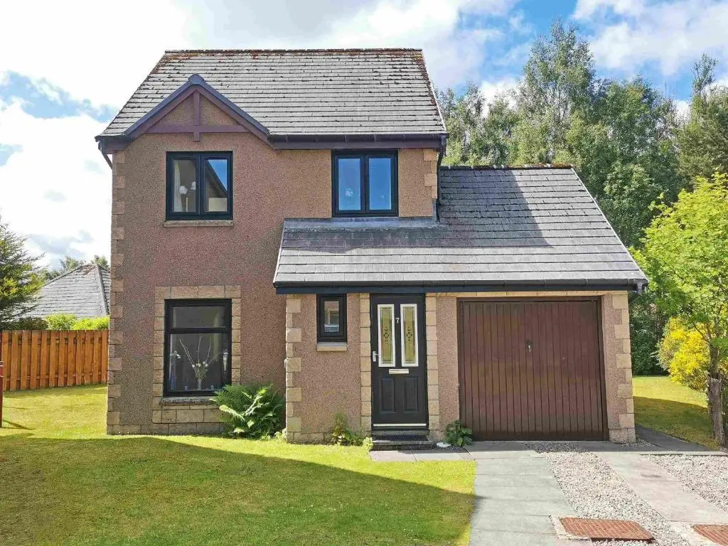 a brick house with a garage in a yard at Birch View in Aviemore