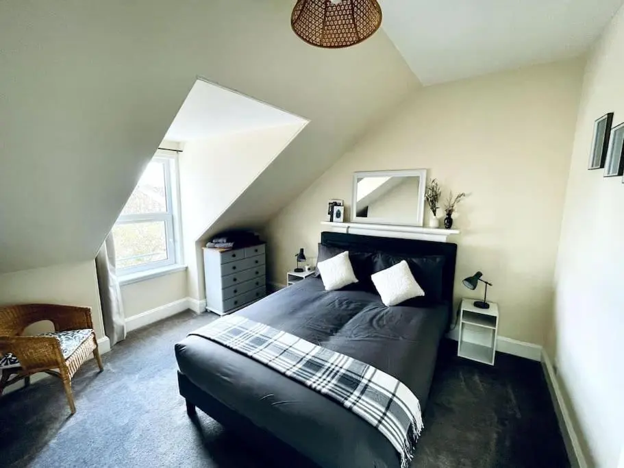 a bedroom with a large black bed in a attic at Charming 3-bedroom maisonnette in Inverness City Centre in Inverness
