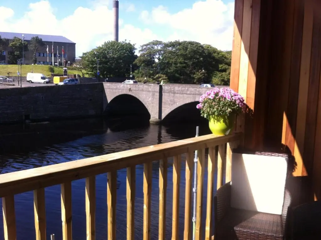a view of a bridge with a flower pot on a balcony at Riverside Apartments in Wick