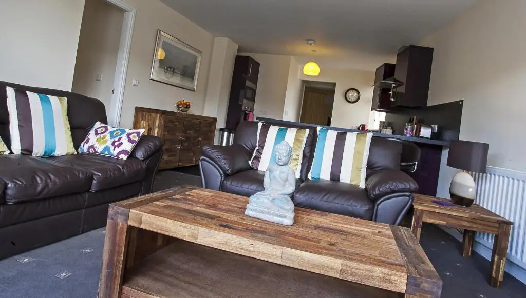 a living room with leather couches and a coffee table at Riverside Apartments in Wick
