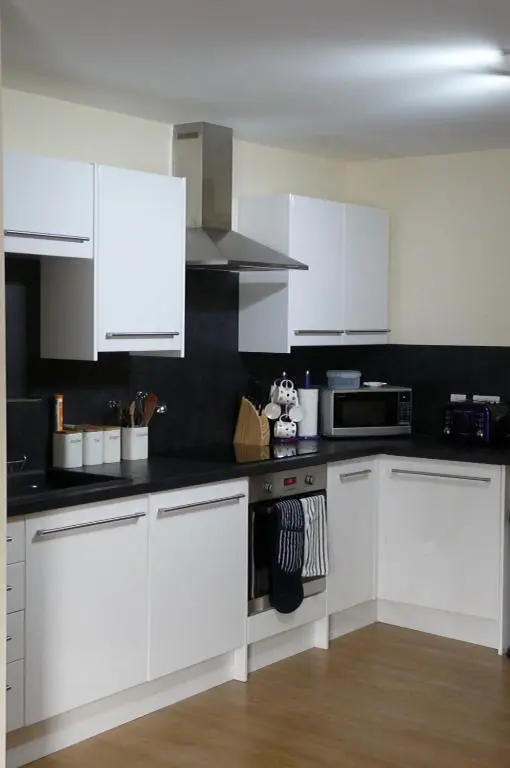 a kitchen with white cabinets and a stove top oven at Riverside Apartments in Wick