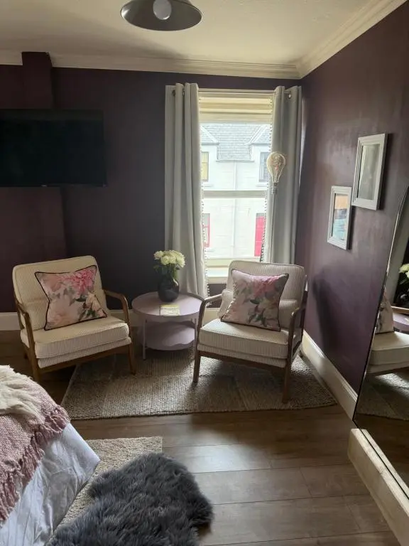 a bedroom with two chairs and a bed and a window at The Salt house in Golspie