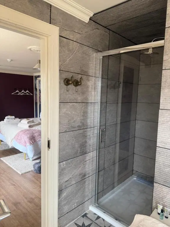 a shower with a glass door in a bedroom at The Salt house in Golspie