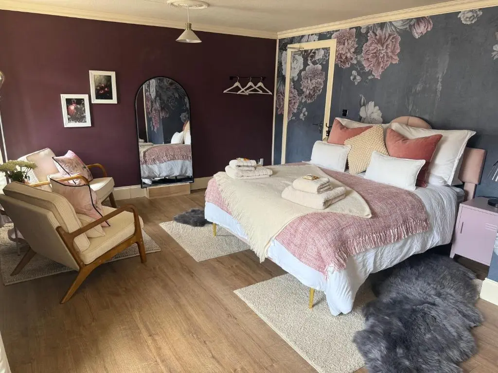 a bedroom with a large bed and a chair at The Salt house in Golspie