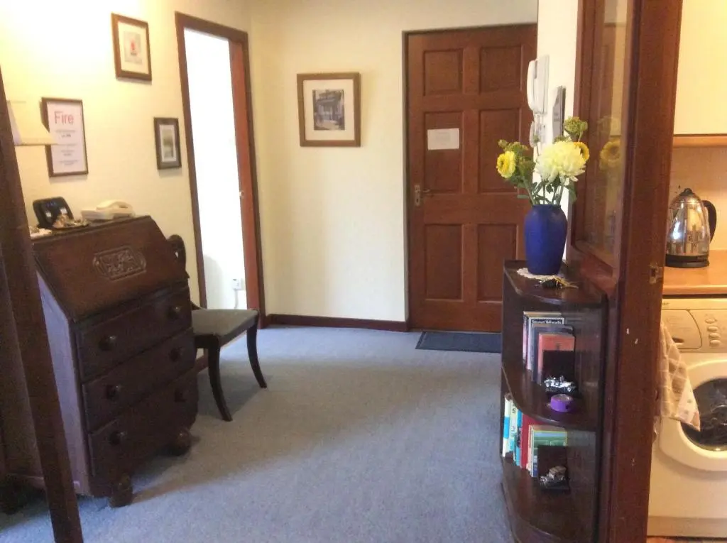 a room with a dresser and a cabinet with flowers on it at Connel Court Apartments in Inverness