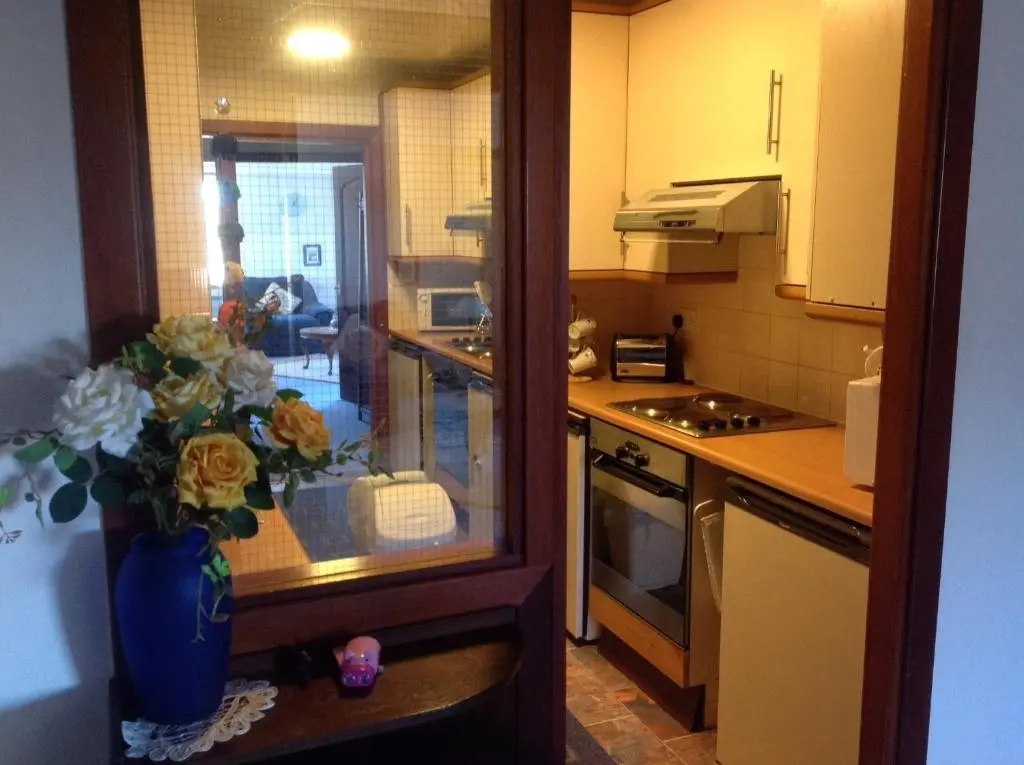 a kitchen with a vase of flowers on a counter at Connel Court Apartments in Inverness