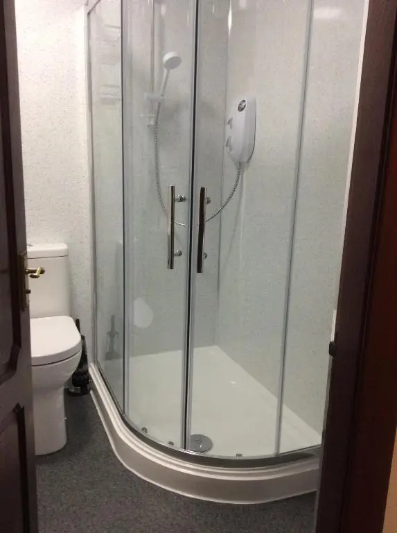 a bathroom with a glass shower with a toilet at Connel Court Apartments in Inverness