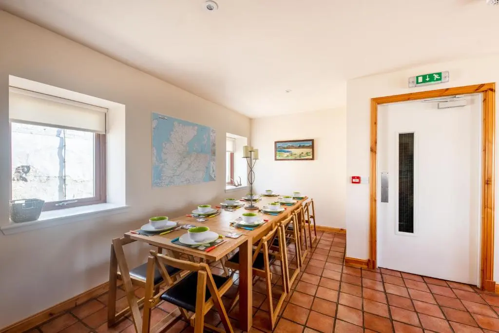a dining room with a long table and chairs at Spacious 6 bedroom property on a working fruit farm in Tore