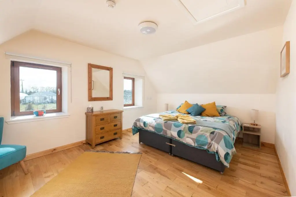 a bedroom with a bed and a window at Spacious 6 bedroom property on a working fruit farm in Tore