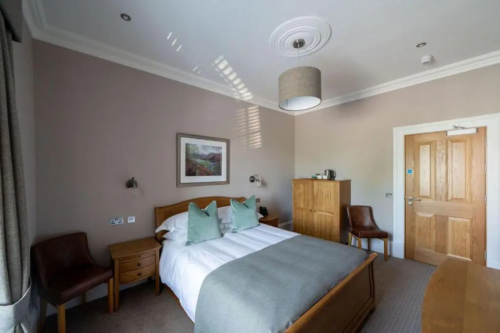 a bedroom with a bed and a table and chairs at The Forbes Arms Hotel in Alford
