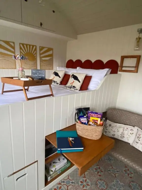 a room with a bed and a couch and a table at Ledmacoy Shepherds Huts in Strathdon