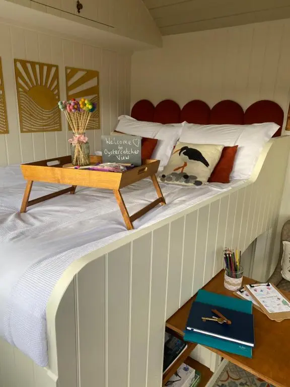 a bed in a room with a table on it at Ledmacoy Shepherds Huts in Strathdon
