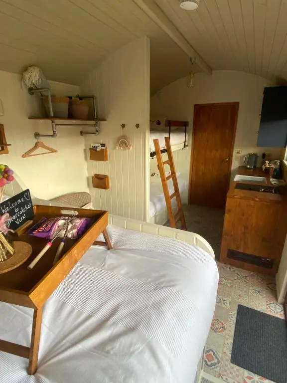 a living room with a bed and a table at Ledmacoy Shepherds Huts in Strathdon