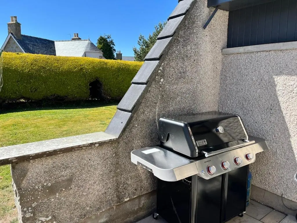 a bbq grill sitting on the side of a wall at Dune House, Golf Road, Dornoch 5x Bedrooms in Dornoch