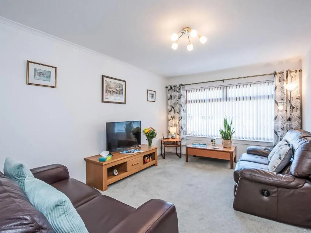 a living room with a couch and a tv at Holiday Home Kincraig by Interhome in Inverness