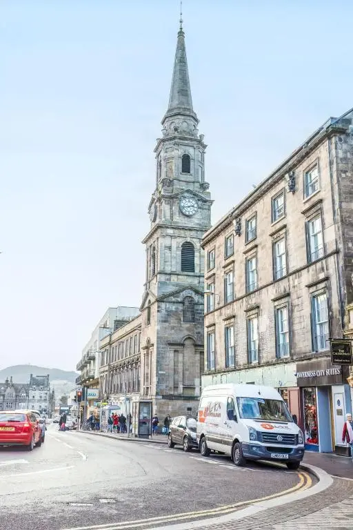 a building with a clock tower on a city street at Holiday Home Kincraig by Interhome in Inverness