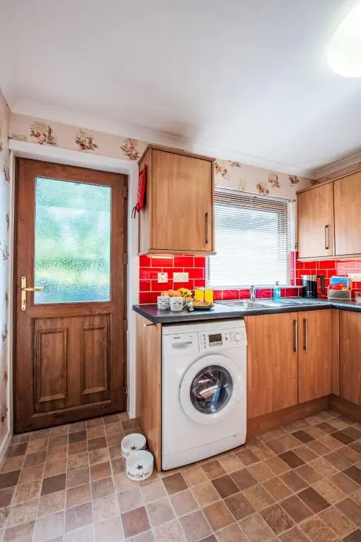 a kitchen with a washing machine and a window at Holiday Home Kincraig by Interhome in Inverness
