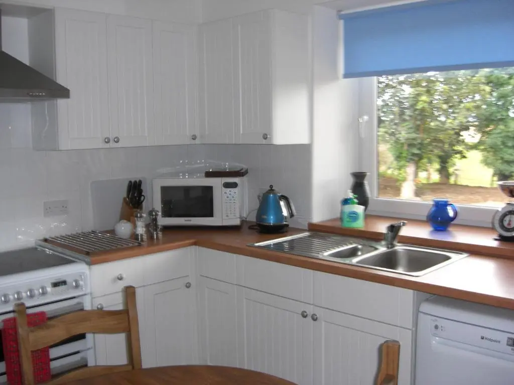 a kitchen with a sink and a microwave at Seggat Farm Holiday Cottages in Kirktown of Auchterless